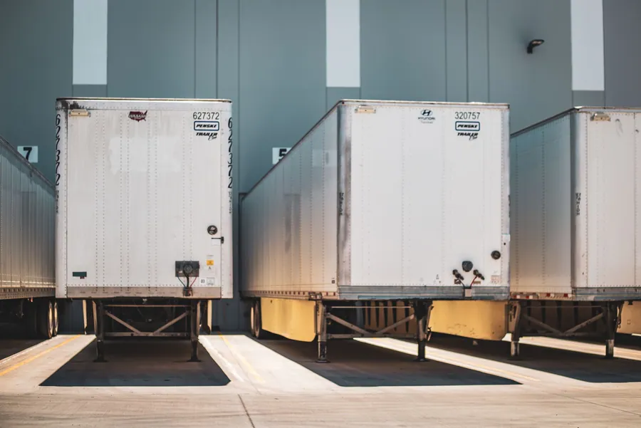 Camions de déménagement alignés au quai de chargement avant le départ