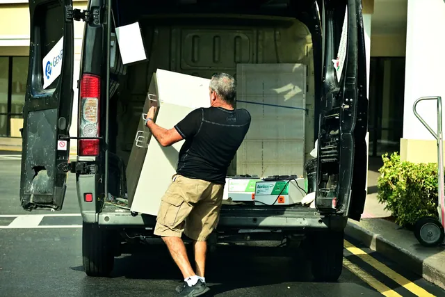Déménageur chargeant du mobilier à l'arrière d'un camion
