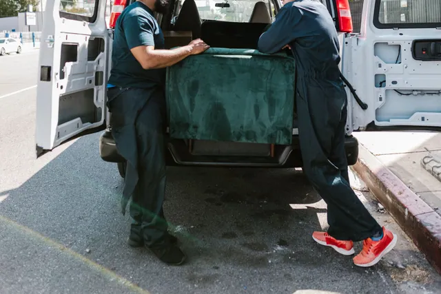 Deux déménageurs chargeant du mobilier dans une camionnette à Bruxelles