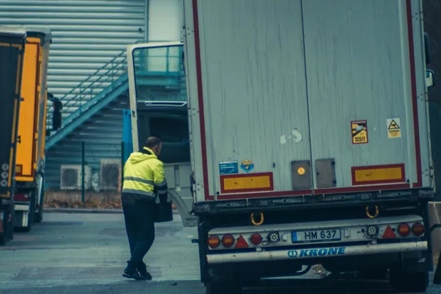 Déménageur en gilet de sécurité rejoignant son camion avant le départ en tournée