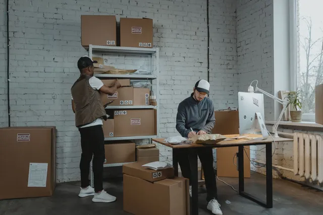 Déménageurs professionnels emballant le mobilier et les cartons d'un bureau
