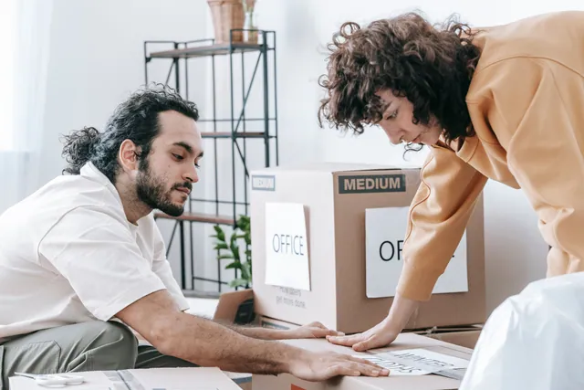 Déménageurs professionnels emballant le mobilier et les cartons d'un bureau